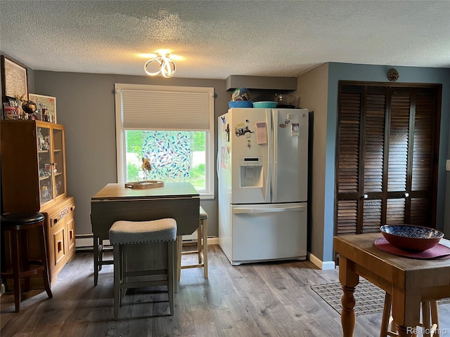 4564 Wildwood Rd, Alger, MI 48610 - kitchen featuring fridge with ice dispenser, wood finished floors, a textured ceiling, a baseboard heating unit, and baseboards