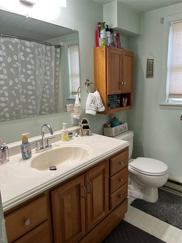 4564 Wildwood Rd, Alger, MI 48610 - bathroom featuring toilet, vanity, a baseboard heating unit, tile patterned flooring, and a shower with shower curtain