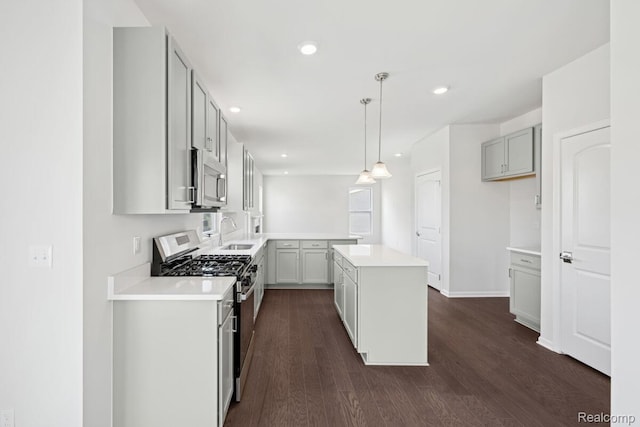 27142 Silo Dr, Saline, MI 48176 - kitchen with appliances with stainless steel finishes, dark wood finished floors, light countertops, a kitchen island, and recessed lighting