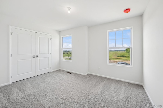 27142 Silo Dr, Saline, MI 48176 - unfurnished bedroom with carpet floors, multiple windows, and a closet