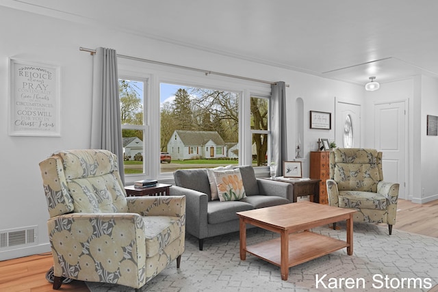 living area featuring visible vents and wood finished floors
