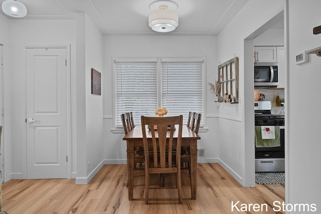 dining area featuring light wood-type flooring and baseboards
