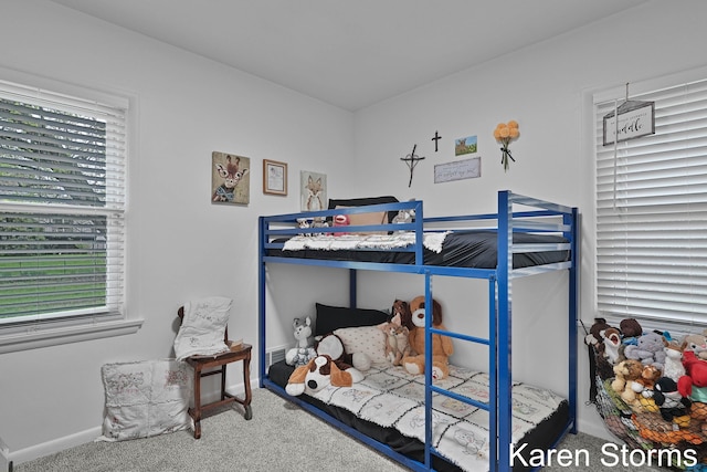 carpeted bedroom with baseboards and multiple windows
