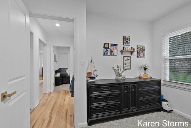 hallway with baseboards, light wood-style floors, and recessed lighting