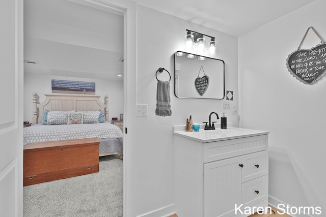 ensuite bathroom featuring vanity, connected bathroom, and baseboards