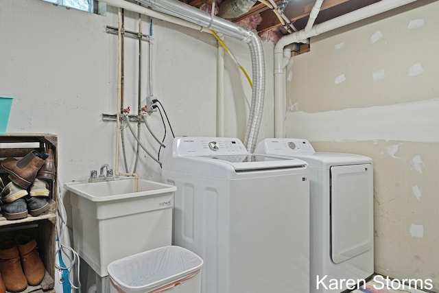 laundry room with laundry area, washing machine and dryer, and a sink