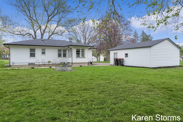 back of house with an outbuilding, a chimney, and a lawn