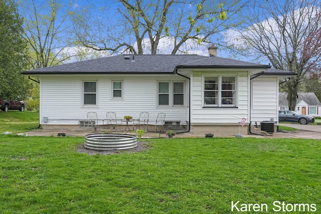 back of house with a chimney, a lawn, cooling unit, a patio, and a shingled roof