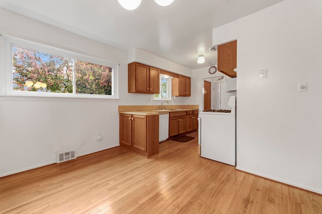 18377 Sunset St, Livonia, MI 48152 - kitchen featuring stove, white dishwasher, a sink, and brown cabinets