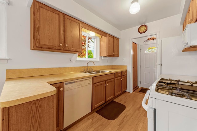18377 Sunset St, Livonia, MI 48152 - kitchen featuring white appliances, a sink, light wood-type flooring, and brown cabinetry