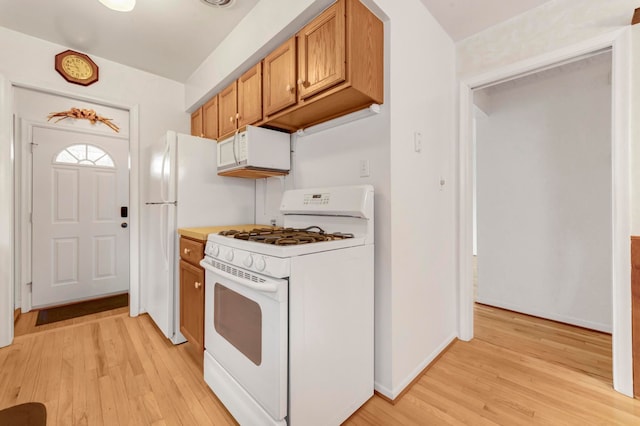 18377 Sunset St, Livonia, MI 48152 - kitchen featuring white appliances, light wood-style floors, brown cabinets, baseboards, and light countertops