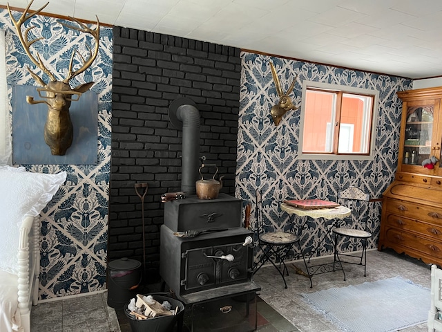 interior space with a wood stove, wallpapered walls, and ornamental molding