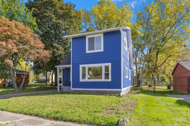 view of front of house with a gate, fence, and a front lawn