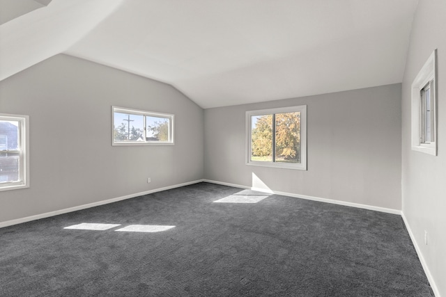 bonus room with lofted ceiling, baseboards, and dark colored carpet