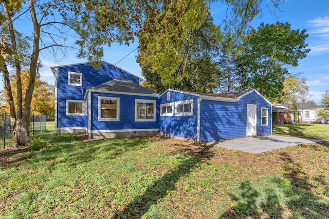 back of property featuring a yard, fence, and a patio
