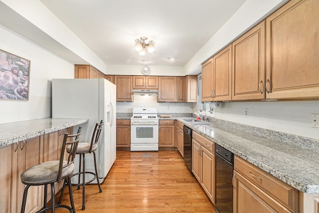 8570 Riverside Dr, Brighton, MI 48116 - kitchen with white appliances, under cabinet range hood, light wood-type flooring, a sink, and a kitchen breakfast bar