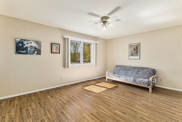8570 Riverside Dr, Brighton, MI 48116 - living area featuring wood finished floors, a ceiling fan, and baseboards