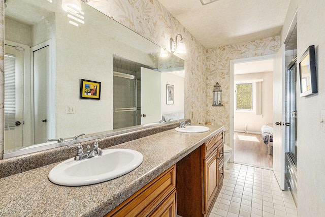 8570 Riverside Dr, Brighton, MI 48116 - full bathroom with tile patterned floors, a shower with shower door, double vanity, and wallpapered walls