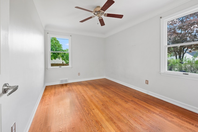 unfurnished room featuring ceiling fan, a wealth of natural light, visible vents, and light wood-style floors
