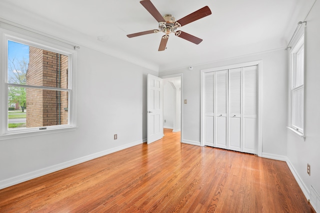 unfurnished bedroom featuring a closet, light wood-type flooring, visible vents, baseboards, and ceiling fan