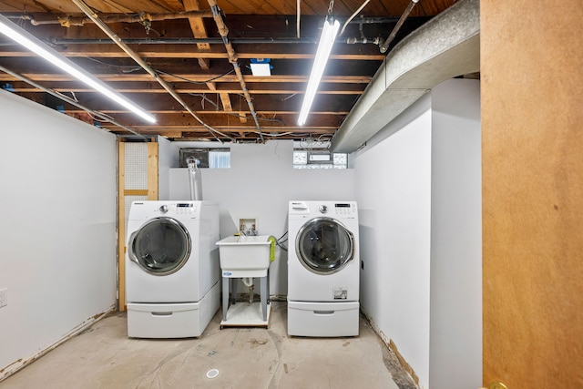 washroom featuring washer and dryer, laundry area, and a sink