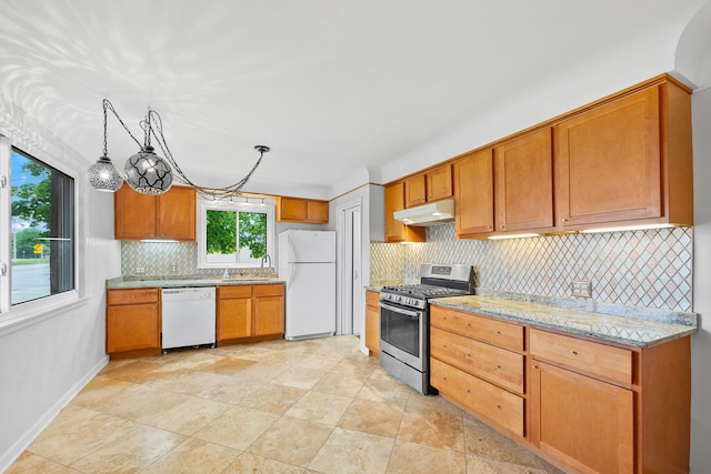kitchen with under cabinet range hood, light stone counters, white appliances, a sink, and decorative backsplash