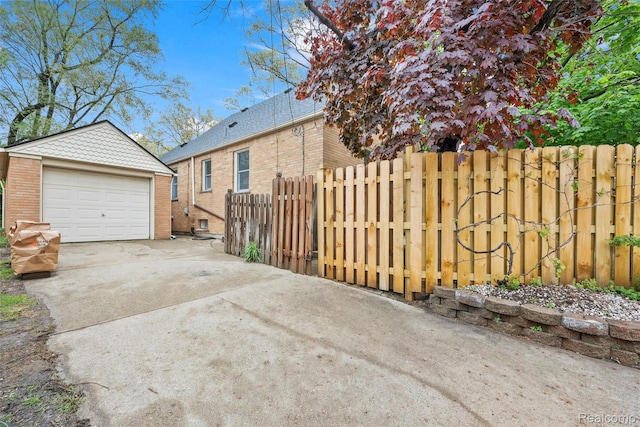 18470 Outer Dr, Dearborn, MI 48128 - view of home's exterior with concrete driveway, an outbuilding, brick siding, and a detached garage