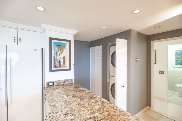 1300 E Lafayette St Unit 902, Detroit, MI 48207 - corridor with stacked washing machine and dryer, recessed lighting, and light tile patterned floors