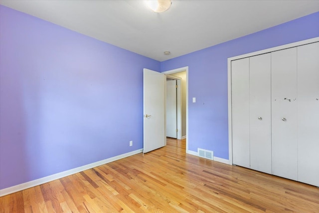 unfurnished bedroom with baseboards, light wood-style floors, a closet, and visible vents