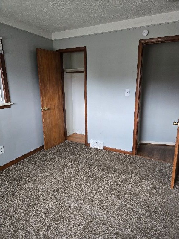 19000 Rosetta Ave, Eastpointe, MI 48021 - unfurnished bedroom featuring carpet, a closet, baseboards, and a textured ceiling