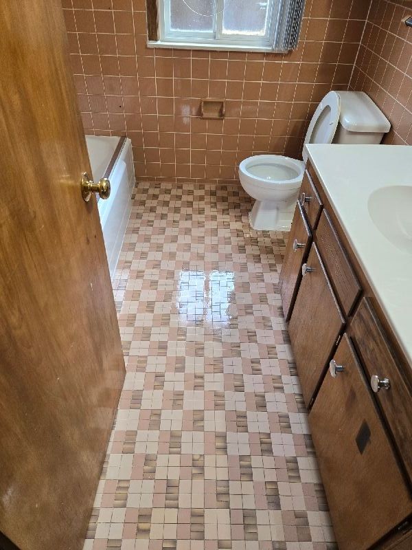 19000 Rosetta Ave, Eastpointe, MI 48021 - full bath featuring toilet, tile walls, vanity, a shower, and a bath