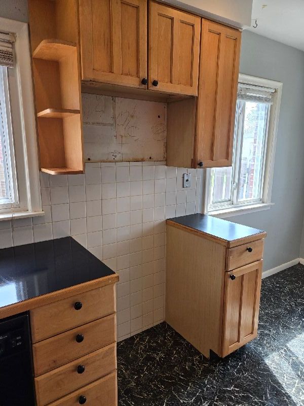 19000 Rosetta Ave, Eastpointe, MI 48021 - kitchen with dishwasher, open shelves, dark countertops, backsplash, and brown cabinetry