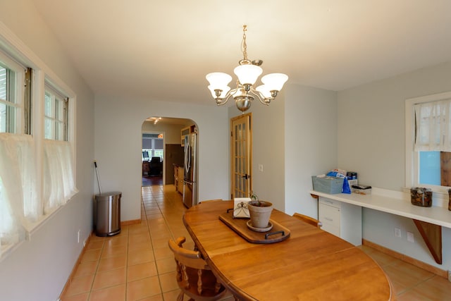 2847 N Custer Rd, Monroe, MI 48162 - dining room featuring arched walkways, light tile patterned floors, a chandelier, and baseboards