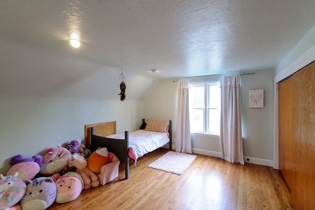 2847 N Custer Rd, Monroe, MI 48162 - bedroom featuring a textured ceiling, wood finished floors, vaulted ceiling, and baseboards