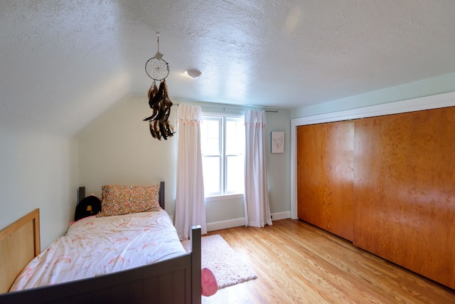 2847 N Custer Rd, Monroe, MI 48162 - bedroom with light wood finished floors, a textured ceiling, and lofted ceiling