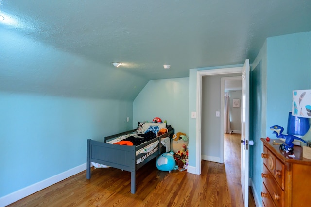 2847 N Custer Rd, Monroe, MI 48162 - bedroom featuring wood finished floors, baseboards, vaulted ceiling, and a textured ceiling
