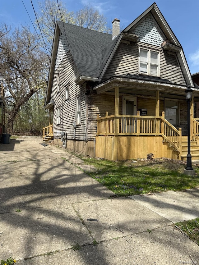 314 W 2nd Ave, Flint, MI 48503 - view of front of house with a porch, a shingled roof, a chimney, and a gambrel roof