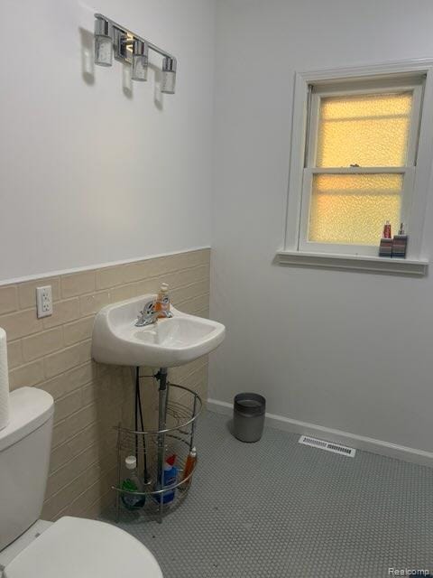 314 W 2nd Ave, Flint, MI 48503 - bathroom featuring toilet and tile walls