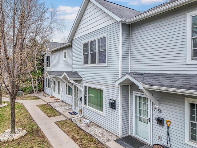 townhome / multi-family property with a shingled roof