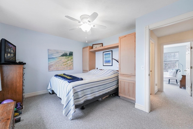 bedroom featuring light colored carpet, baseboards, and ceiling fan