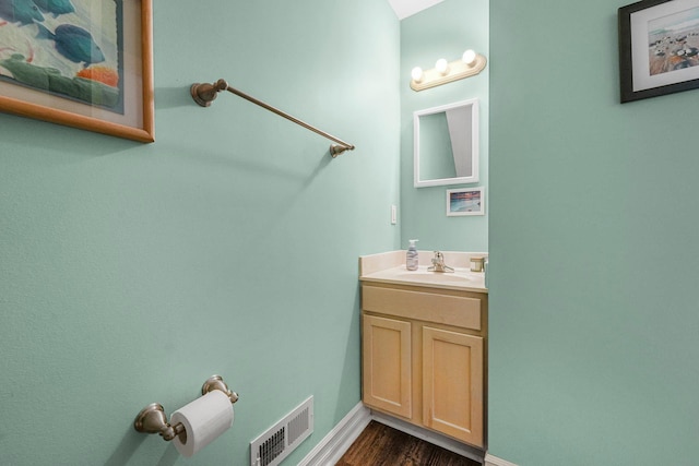 bathroom with vanity, baseboards, and wood finished floors