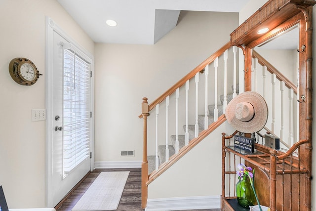 foyer entrance featuring wood finished floors, baseboards, stairs, and recessed lighting