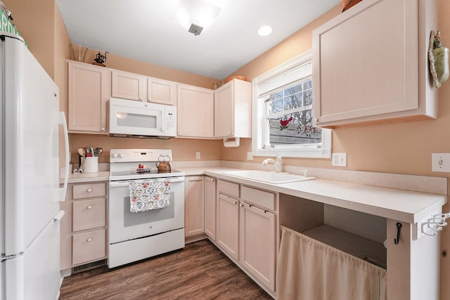 kitchen featuring white appliances, a sink, dark wood-type flooring, light countertops, and recessed lighting
