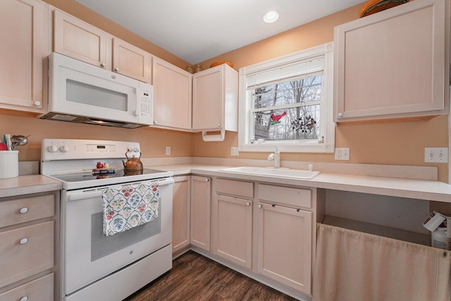 kitchen featuring white appliances, a sink, light countertops, dark wood finished floors, and recessed lighting