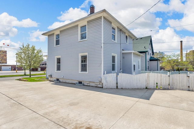 1212 Forest Ave, Jackson, MI 49201 - view of home's exterior with a gate, fence, and a chimney