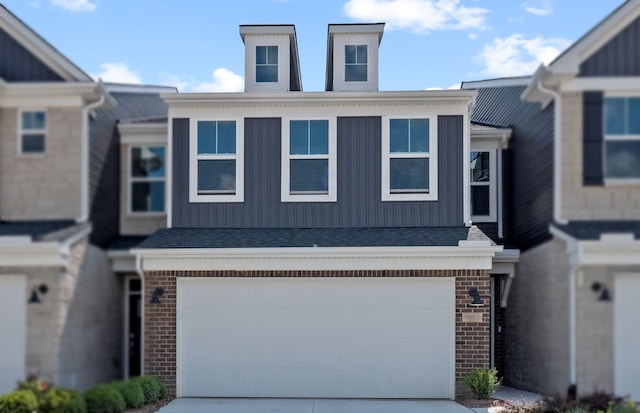 townhome / multi-family property featuring brick siding, driveway, and a garage