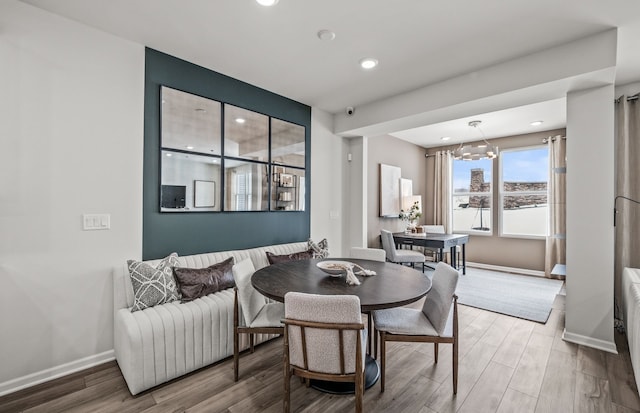 dining room featuring an inviting chandelier, wood finished floors, baseboards, and recessed lighting