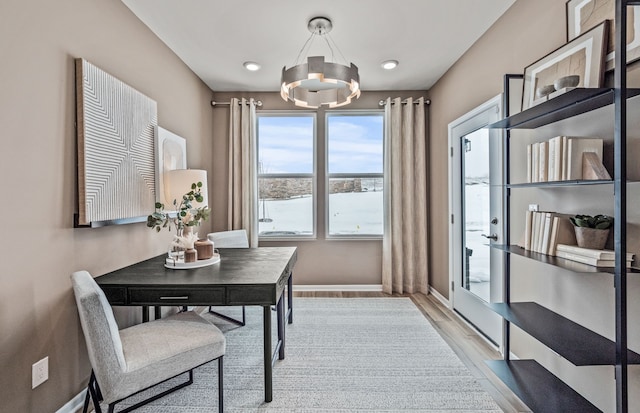 office area featuring an inviting chandelier, light wood-style floors, and baseboards