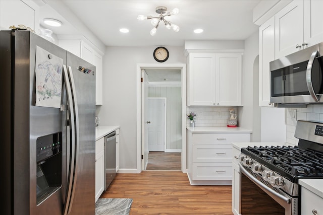 11389 Gold Arbor Rd, Plymouth, MI 48170 - kitchen featuring stainless steel appliances, light countertops, light wood-type flooring, white cabinetry, and tasteful backsplash