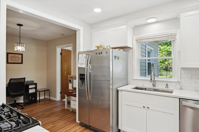 11389 Gold Arbor Rd, Plymouth, MI 48170 - kitchen featuring stainless steel appliances, a sink, tasteful backsplash, wood finished floors, and white cabinets
